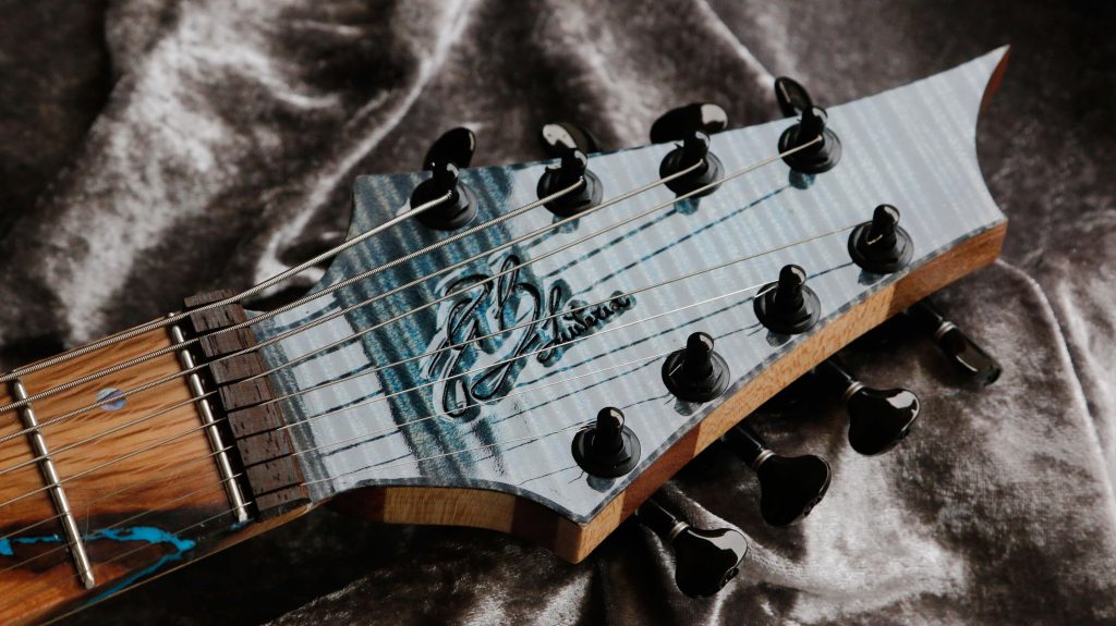 chitarra kapooya 8 corde fanned body in mogano top in acero fiammato con resina luminescente effetto lichtenberg colore blu foto paletta abbinata e logo GB Liuteria capotasto zero fret con guida in wenge