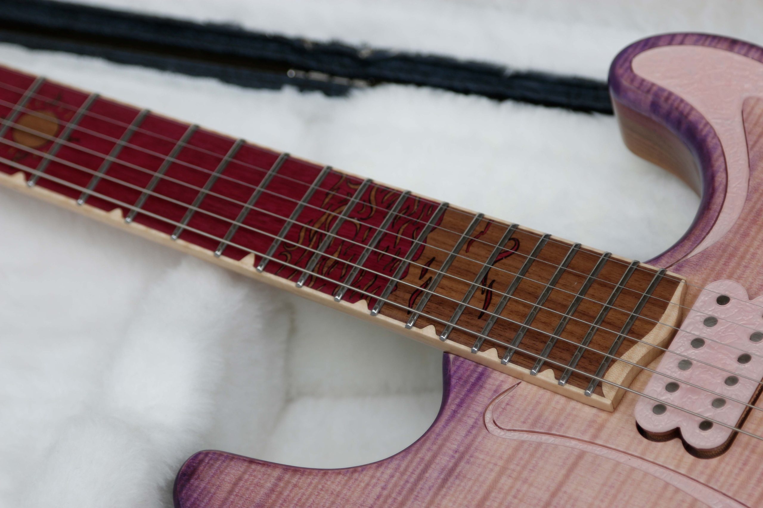 Chitarra Boutique Petra 6 corde colore rosa top in acero fiammato selezionato con inserti in policarbonato retrodecorato in resina rosa madreperla foto tastierta in amaranto con inlay nuvole mare e sole in noce nero e binding in acero naturale foto in tralice parte bassa