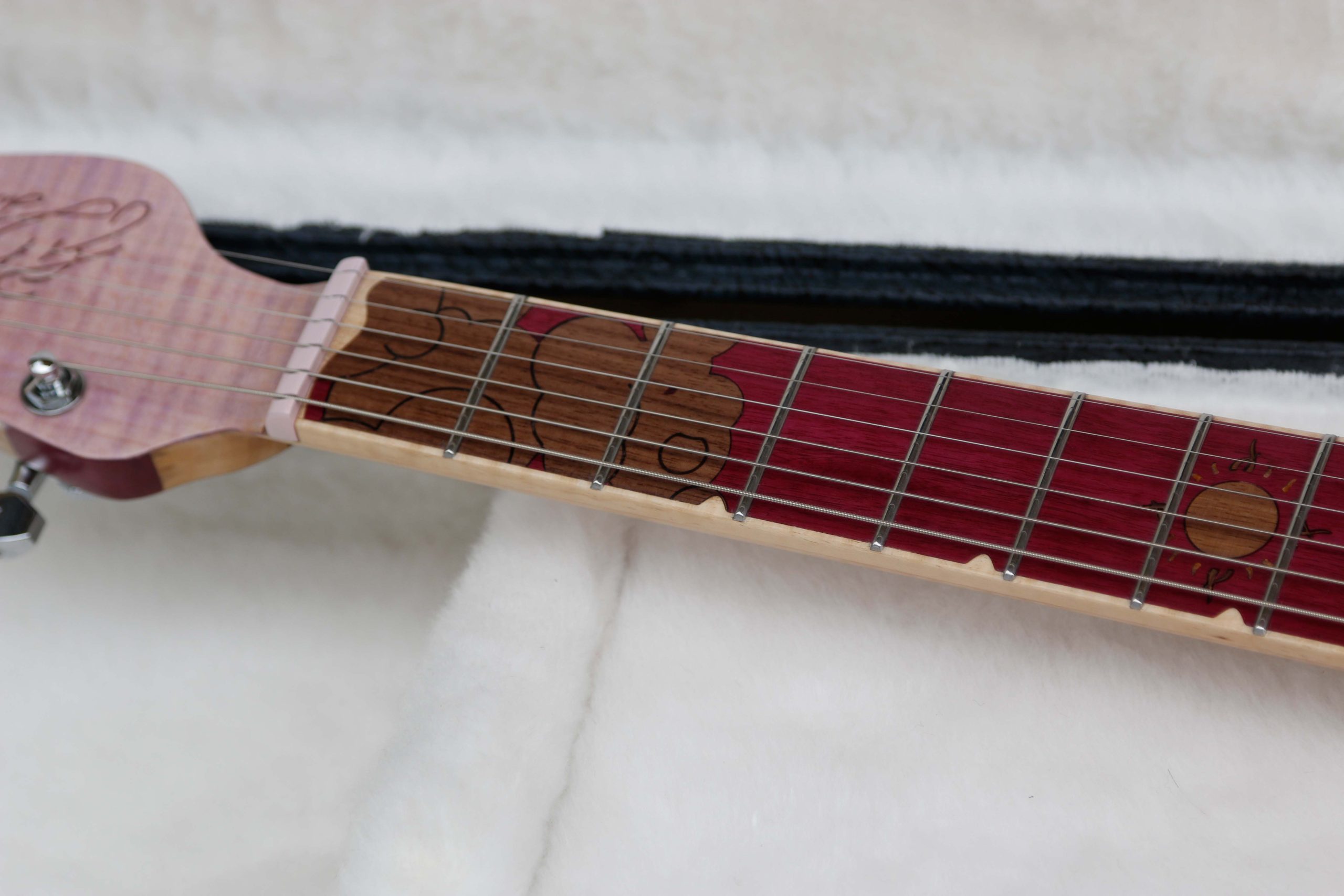 Chitarra Boutique Petra 6 corde colore rosa top in acero fiammato selezionato con inserti in policarbonato retrodecorato in resina rosa madreperla foto tastierta in amaranto con inlay nuvole mare e sole in noce nero e binding in acero naturale foto in tralice parte alta