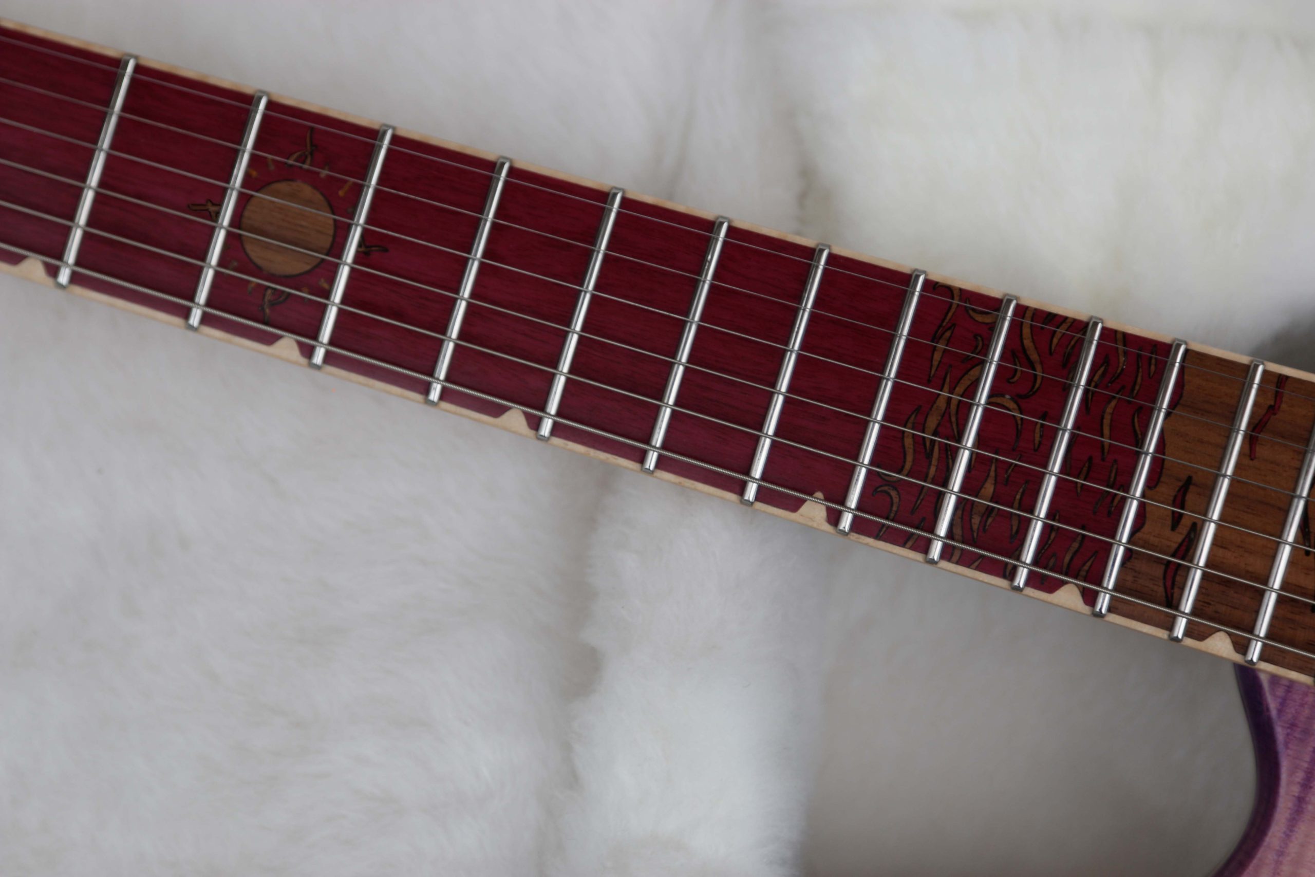 Chitarra Boutique Petra 6 corde colore rosa top in acero fiammato selezionato con inserti in policarbonato retrodecorato in resina rosa madreperla foto tastierta in amaranto con inlay nuvole mare e sole in noce nero e binding in acero naturale parte bassa