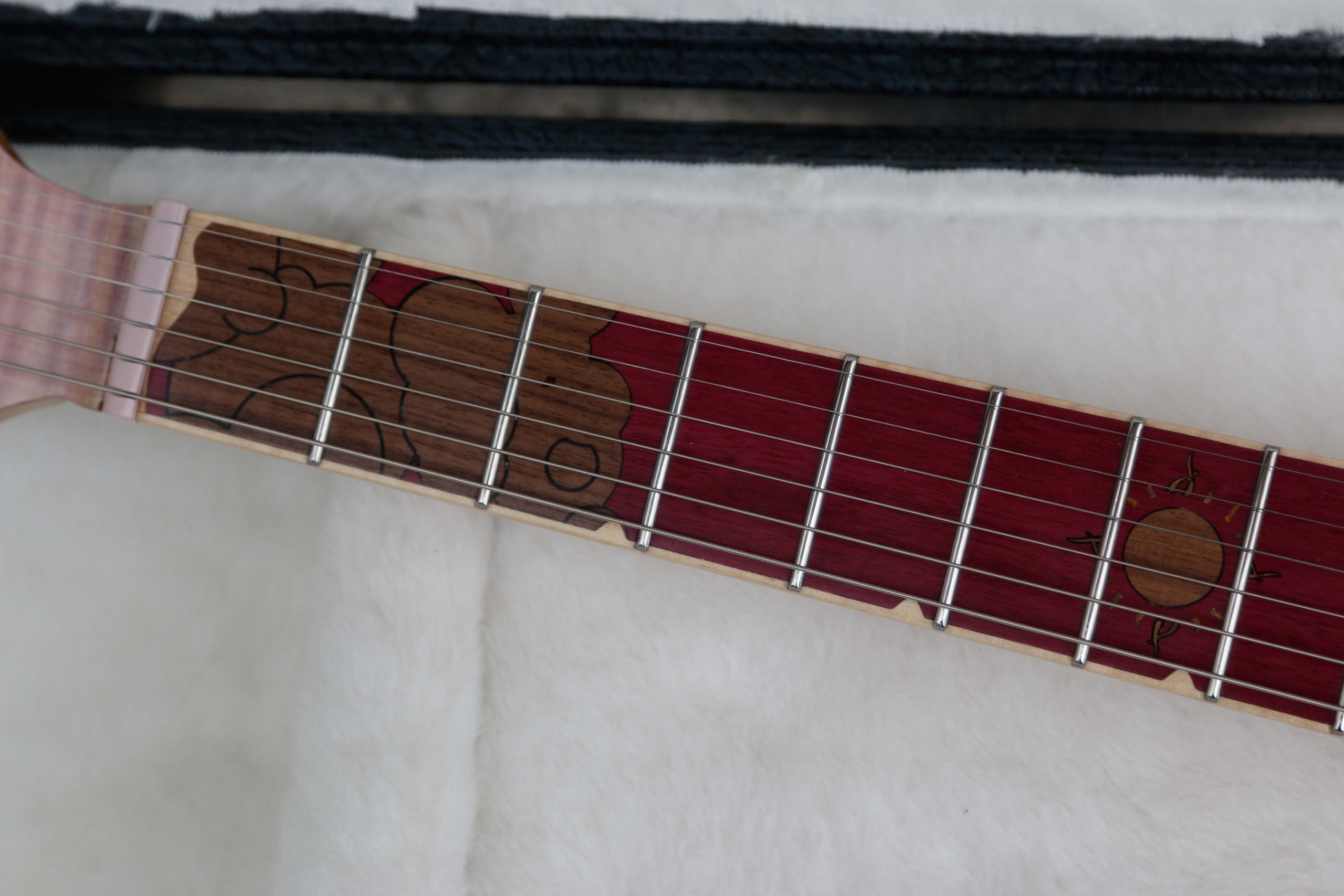 Chitarra Boutique Petra 6 corde colore rosa top in acero fiammato selezionato con inserti in policarbonato retrodecorato in resina rosa madreperla foto tastierta in amaranto con inlay nuvole mare e sole in noce nero e binding in acero naturale parte alta