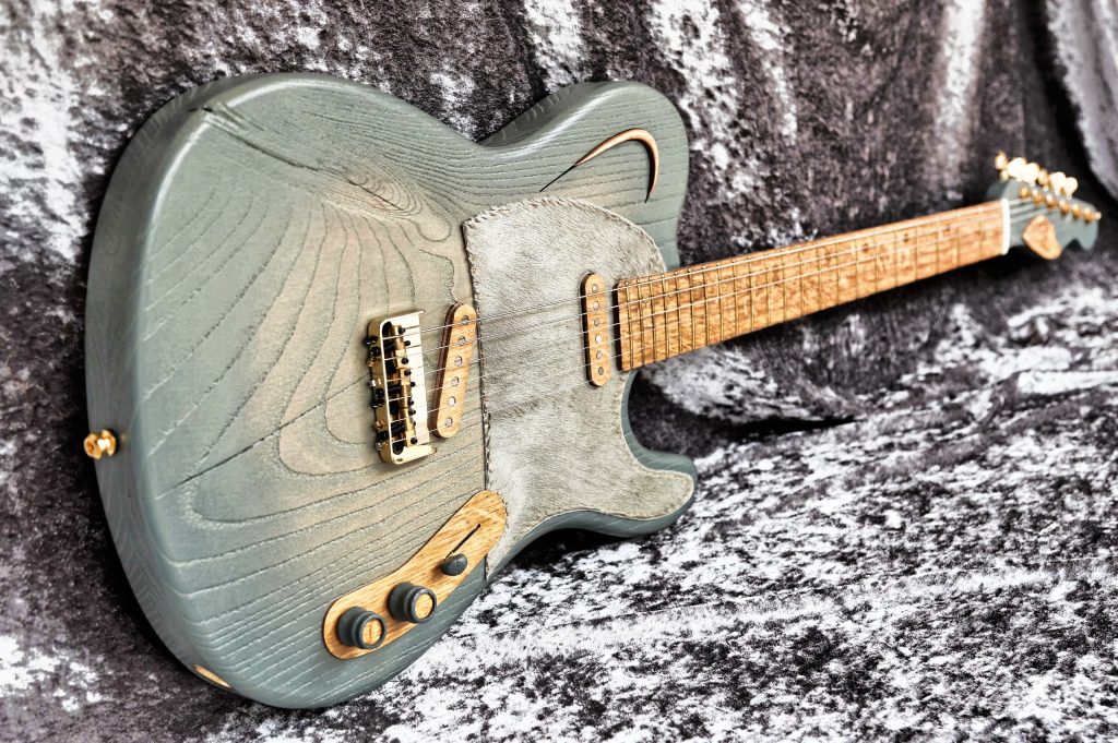 Chitarra Boutique Blouse 6 corde colore verde anticato top in frassino selezionato con spacchi pickguard in pelle di cavallino naturale foto inclinata sx